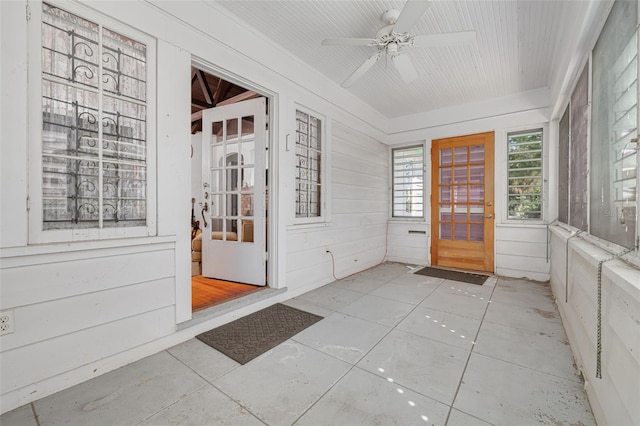 unfurnished sunroom featuring ceiling fan