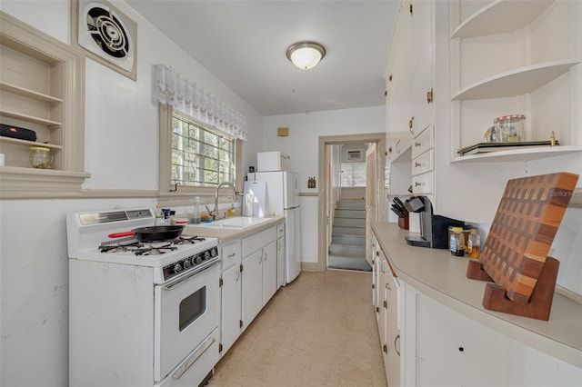 kitchen featuring sink, white cabinets, and white appliances