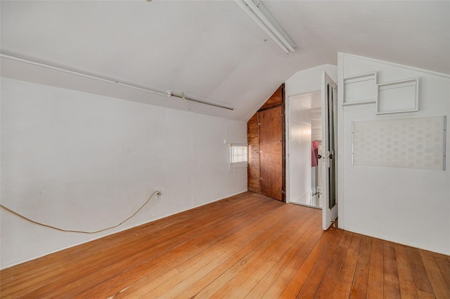 unfurnished room with wood-type flooring and vaulted ceiling