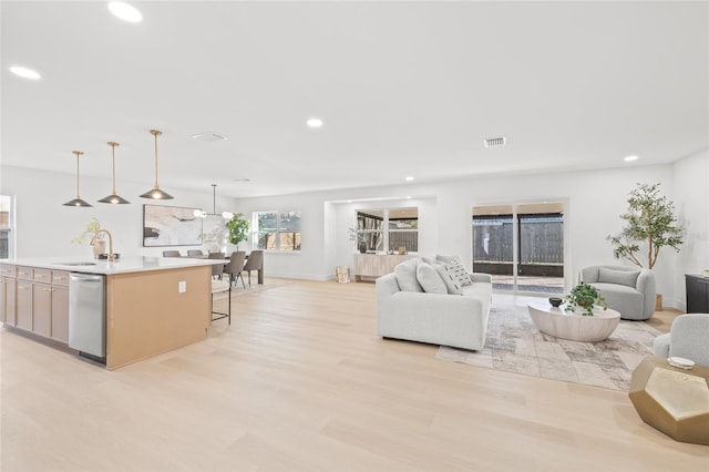 living room with sink and light wood-type flooring