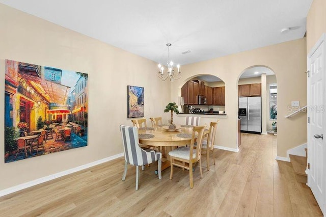 dining room featuring an inviting chandelier and light hardwood / wood-style flooring