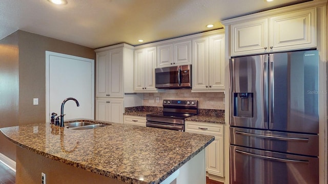 kitchen featuring white cabinetry, stainless steel appliances, sink, and a center island with sink