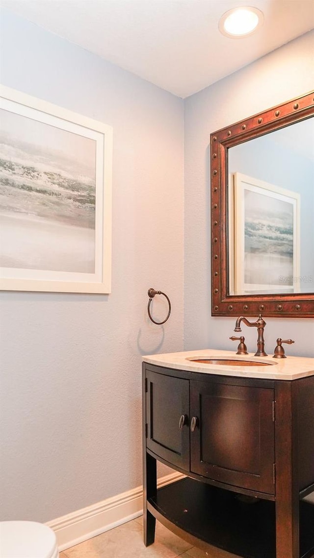 bathroom featuring tile patterned flooring, vanity, and toilet