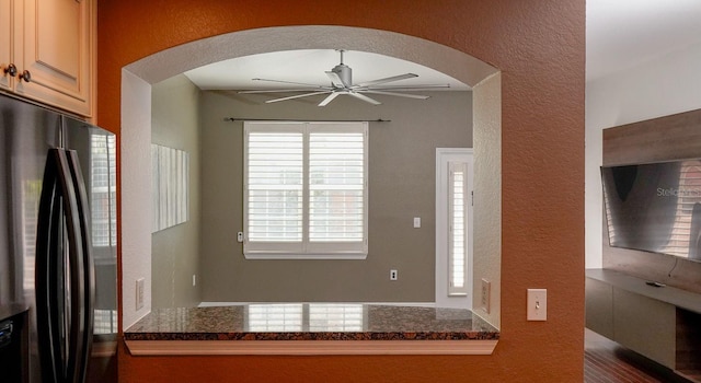 kitchen with ceiling fan and black fridge with ice dispenser