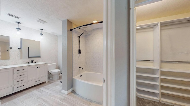 bathroom with vanity, toilet, and a textured ceiling