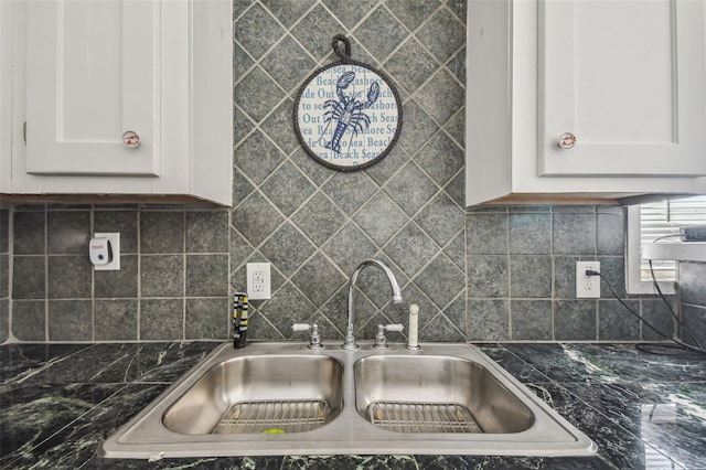 kitchen with sink, white cabinets, dark stone counters, and decorative backsplash