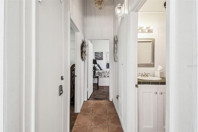 hall with dark tile patterned flooring and sink