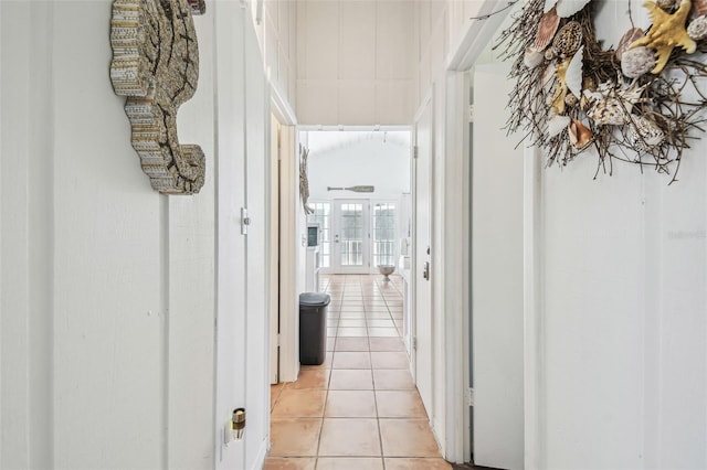 hall featuring light tile patterned floors and french doors