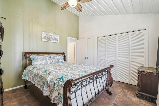 bedroom with ceiling fan, wooden walls, and vaulted ceiling