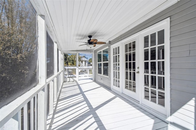 unfurnished sunroom with wood ceiling and ceiling fan