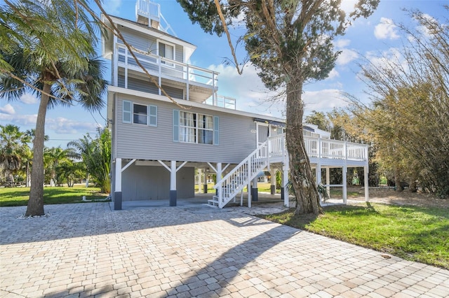 view of front of home featuring a carport, a balcony, and a front lawn