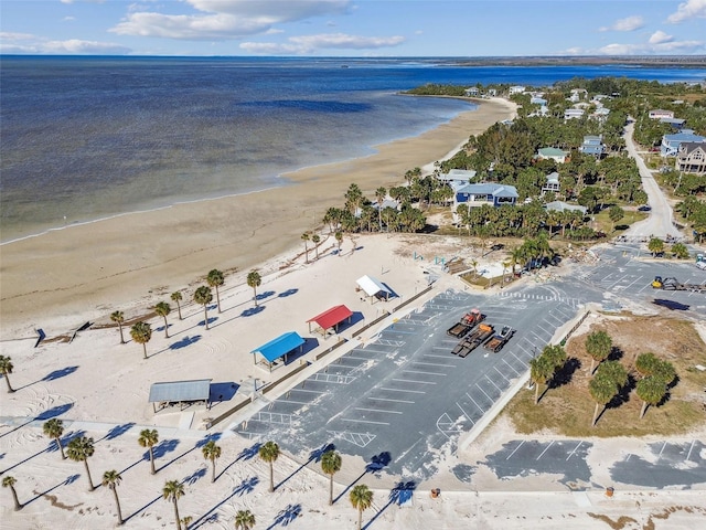 birds eye view of property with a water view and a beach view