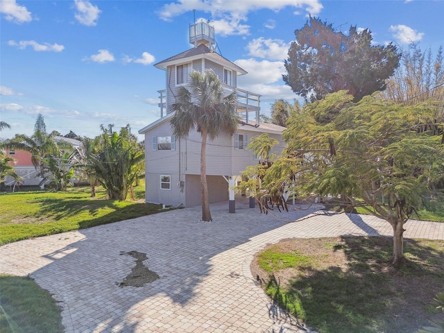 view of front of house featuring a balcony and a front yard