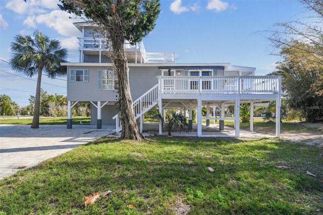 view of front facade with a carport, a deck, and a front lawn