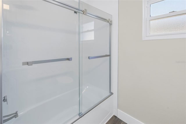 bathroom featuring combined bath / shower with glass door