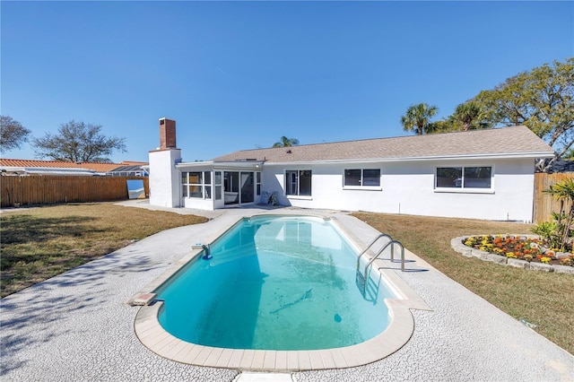 view of swimming pool featuring a sunroom and a yard