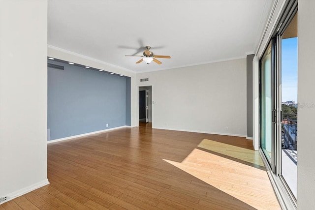 unfurnished room featuring wood-type flooring, ornamental molding, ceiling fan, and a wall of windows