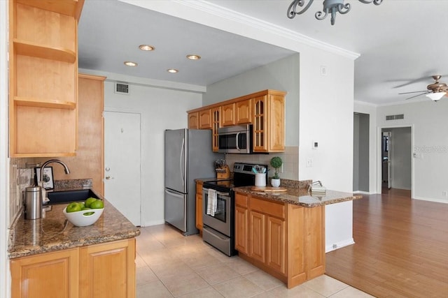 kitchen featuring sink, decorative backsplash, dark stone counters, stainless steel appliances, and crown molding