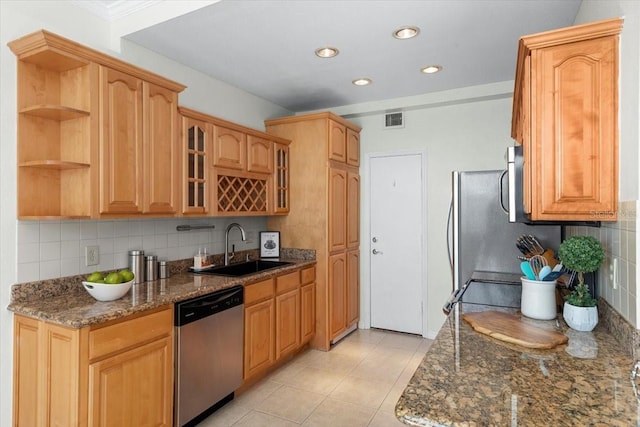 kitchen featuring backsplash, appliances with stainless steel finishes, sink, and dark stone counters