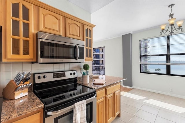 kitchen featuring light tile patterned floors, appliances with stainless steel finishes, dark stone countertops, backsplash, and ornamental molding