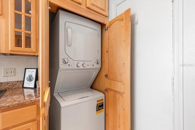 clothes washing area with stacked washer and dryer