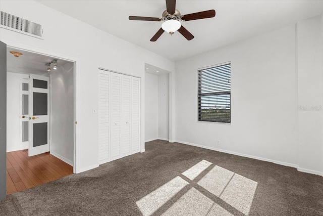 unfurnished bedroom featuring a closet, ceiling fan, and dark colored carpet