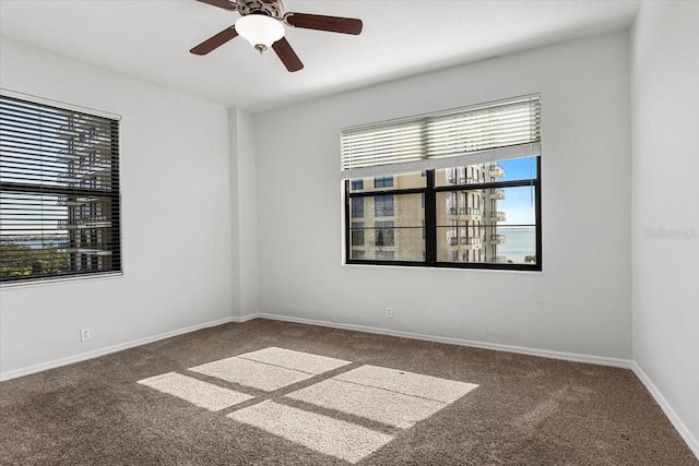 carpeted spare room featuring ceiling fan