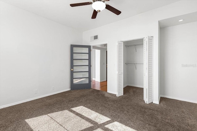 unfurnished bedroom featuring ceiling fan, a closet, and dark colored carpet