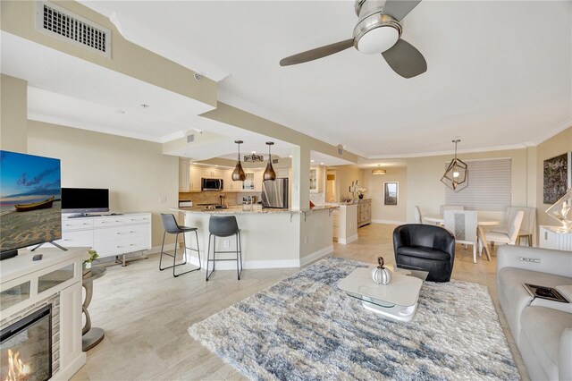 living room with crown molding and ceiling fan