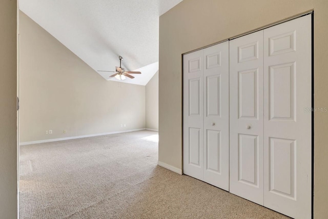 unfurnished bedroom with vaulted ceiling, light colored carpet, and ceiling fan