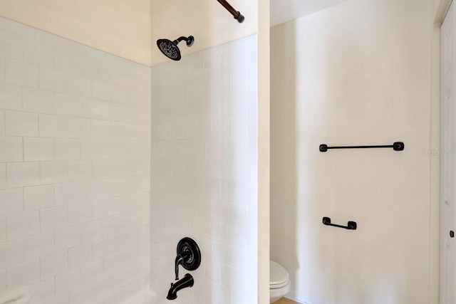 bathroom with tiled shower / bath and toilet