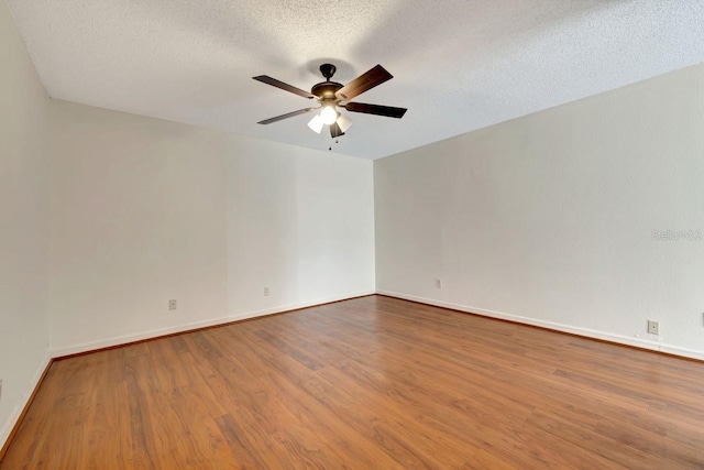 spare room featuring ceiling fan, hardwood / wood-style flooring, and a textured ceiling