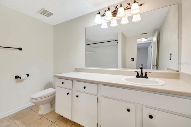 bathroom with vanity, tile patterned floors, toilet, and a textured ceiling