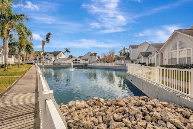 exterior space featuring a water view, a residential view, and fence