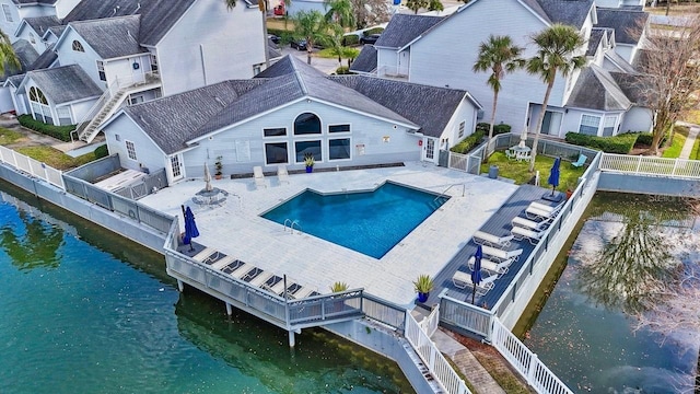 exterior space with a patio area, a water view, a fenced backyard, and a community pool