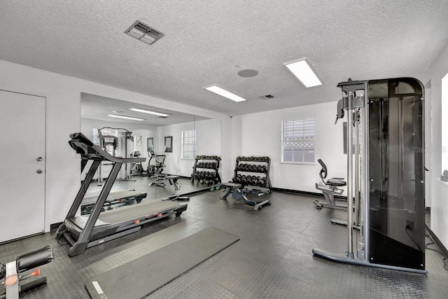 workout area with plenty of natural light and a textured ceiling