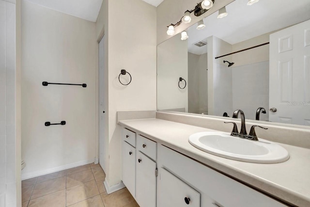 bathroom with walk in shower, tile patterned flooring, vanity, and baseboards