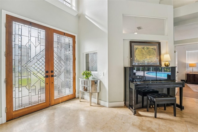 foyer entrance featuring a high ceiling and french doors