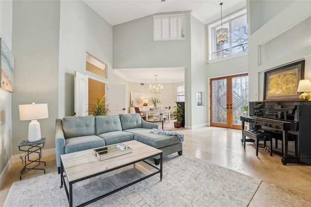 living room with an inviting chandelier, crown molding, french doors, and a high ceiling