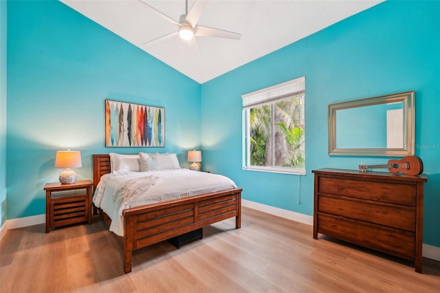 bedroom with ceiling fan, lofted ceiling, and light wood-type flooring