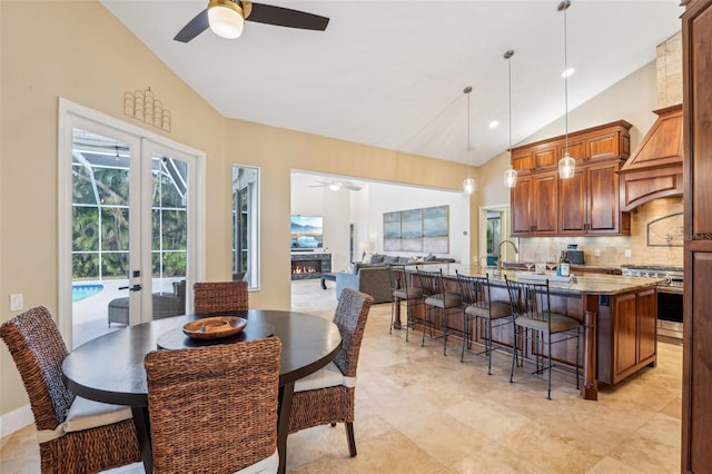 dining room with high vaulted ceiling, sink, ceiling fan, and french doors