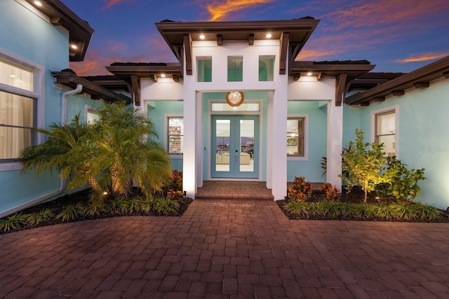 exterior entry at dusk featuring french doors