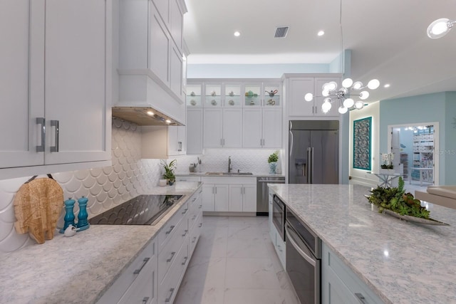 kitchen featuring sink, white cabinetry, appliances with stainless steel finishes, pendant lighting, and decorative backsplash