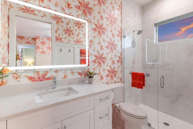 bathroom featuring vanity, a shower with door, and toilet