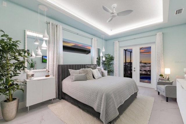 bedroom with radiator, access to exterior, ceiling fan, a tray ceiling, and french doors