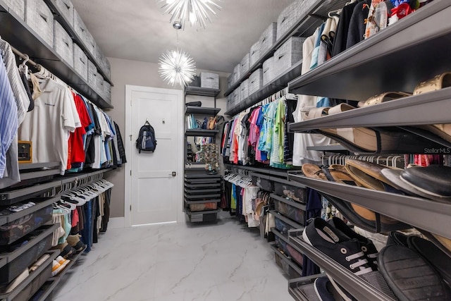 walk in closet featuring an inviting chandelier