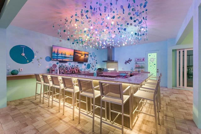 bar with wall chimney exhaust hood and stone counters