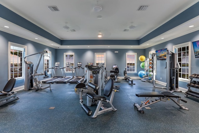 workout area with a tray ceiling and ornamental molding