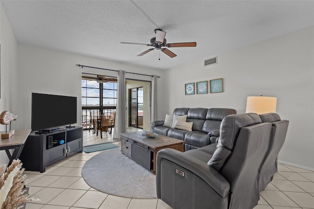 living room with light tile patterned floors, a textured ceiling, and ceiling fan