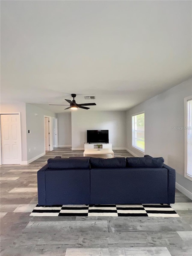 living room with ceiling fan and light wood-type flooring